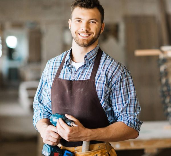 smiling-craftsman-with-electric-drill-min
